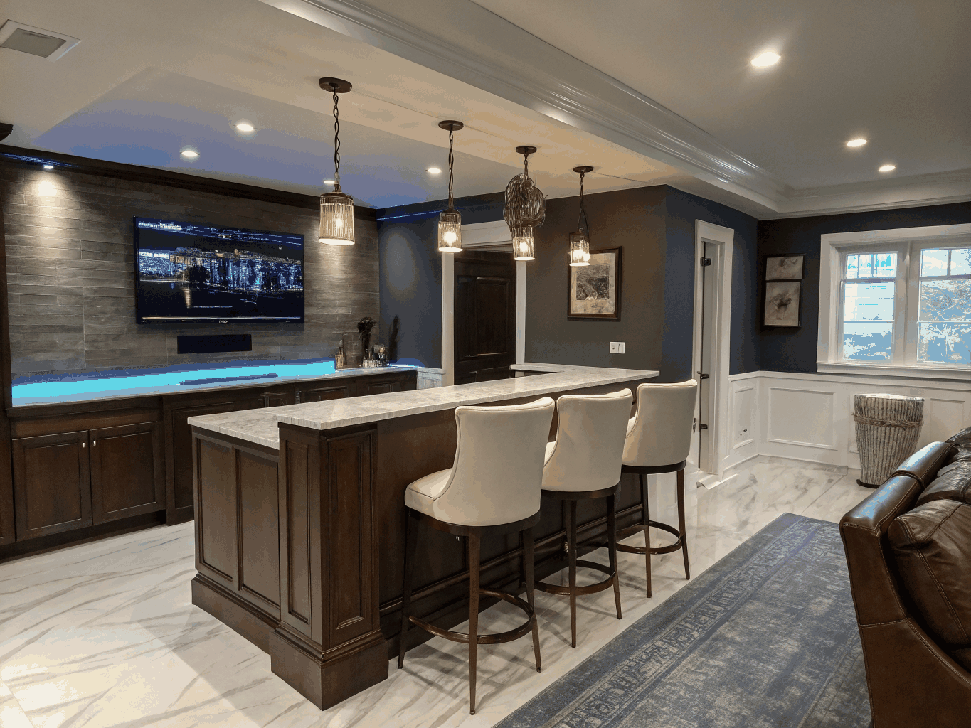 Finished basement entertainment space with bar seating and ambient lighting
