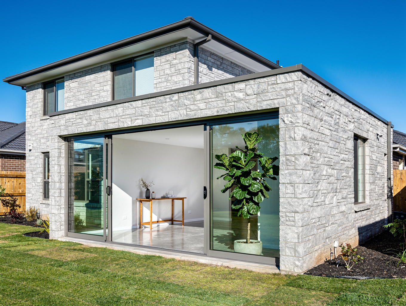Architectural home addition with vaulted timber ceiling and expansive black-framed windows